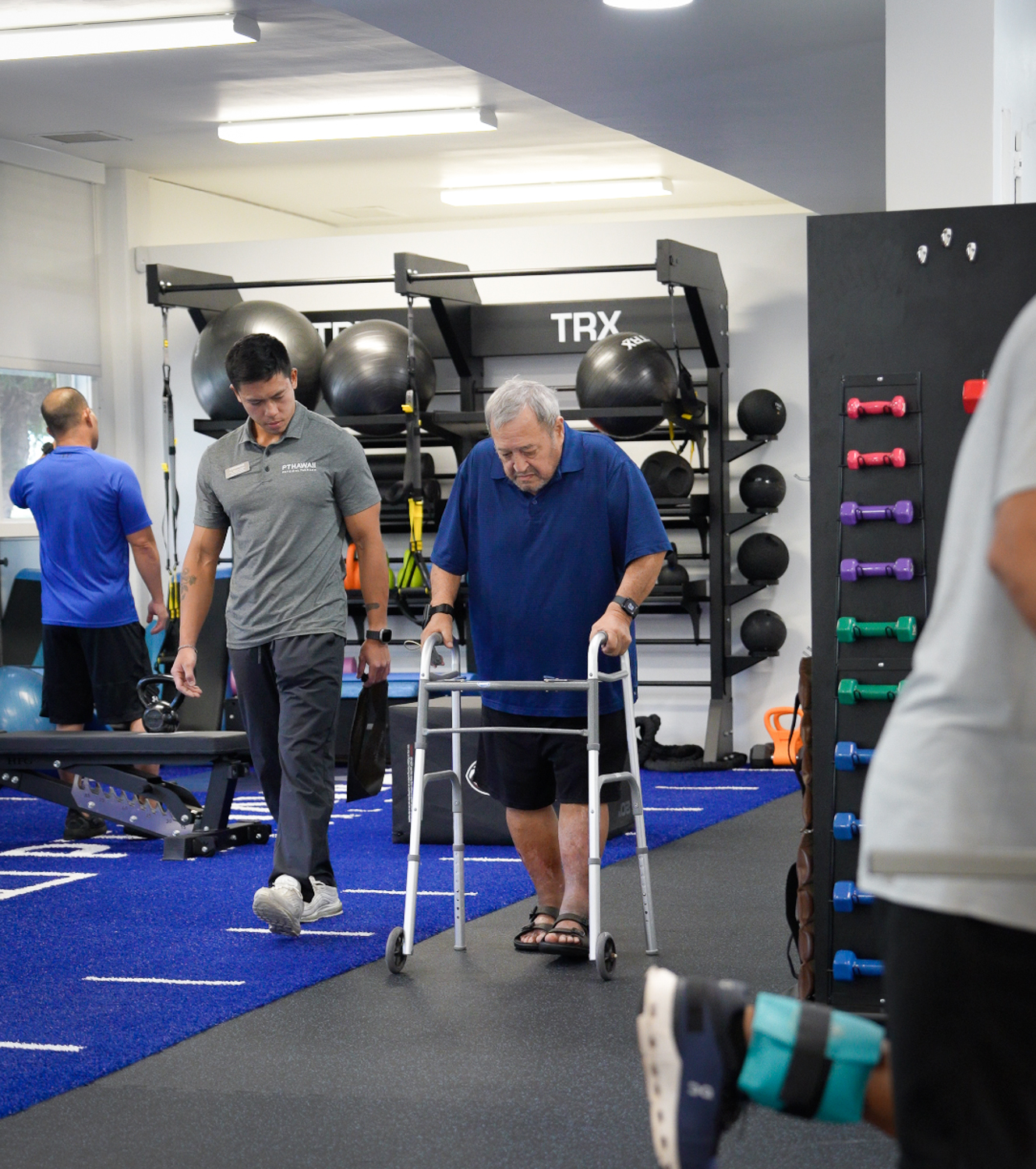 PT Hawaii therapist assisting an older patient using a walker during a rehabilitation session.