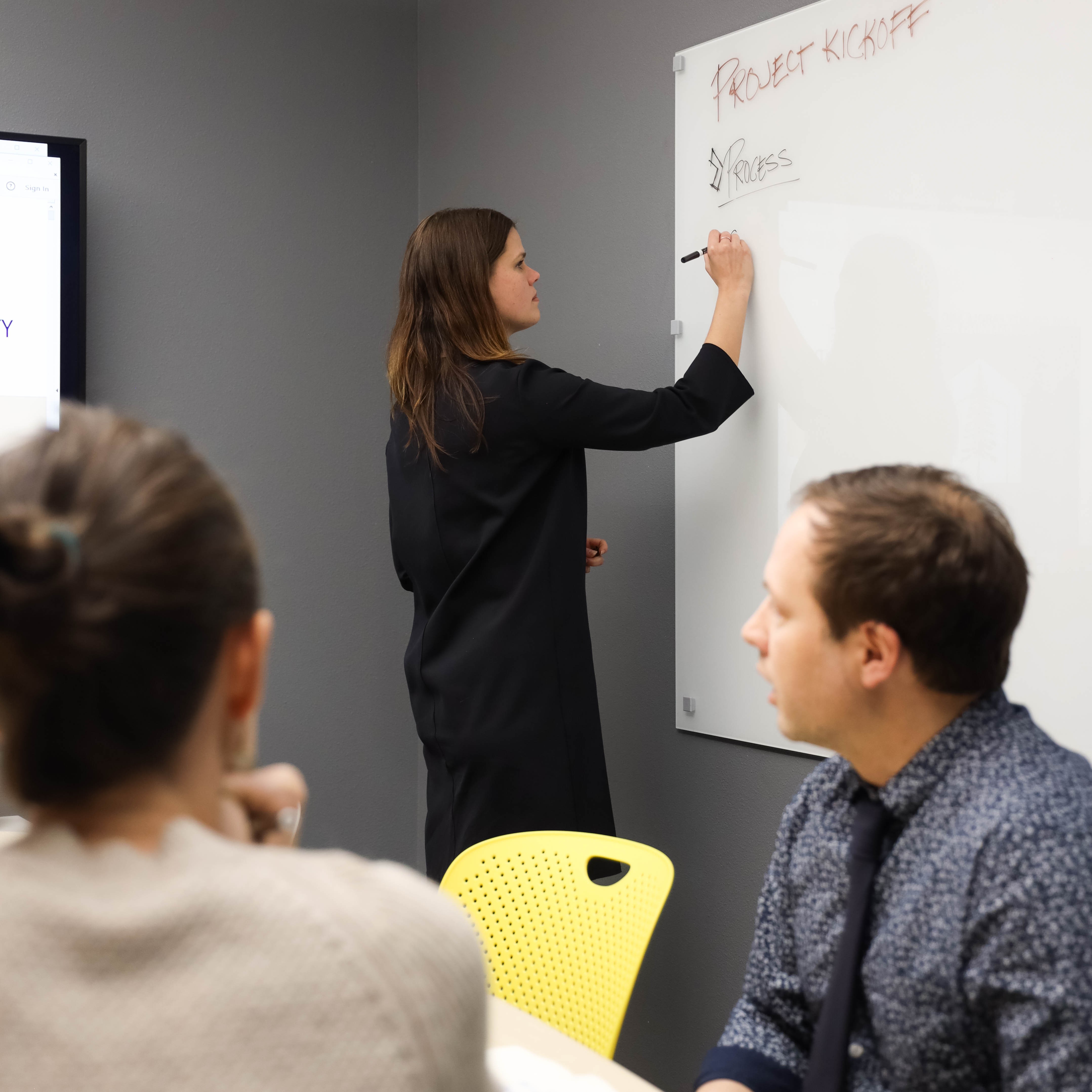 Image of architect writing project kick off detail on a white board. 
