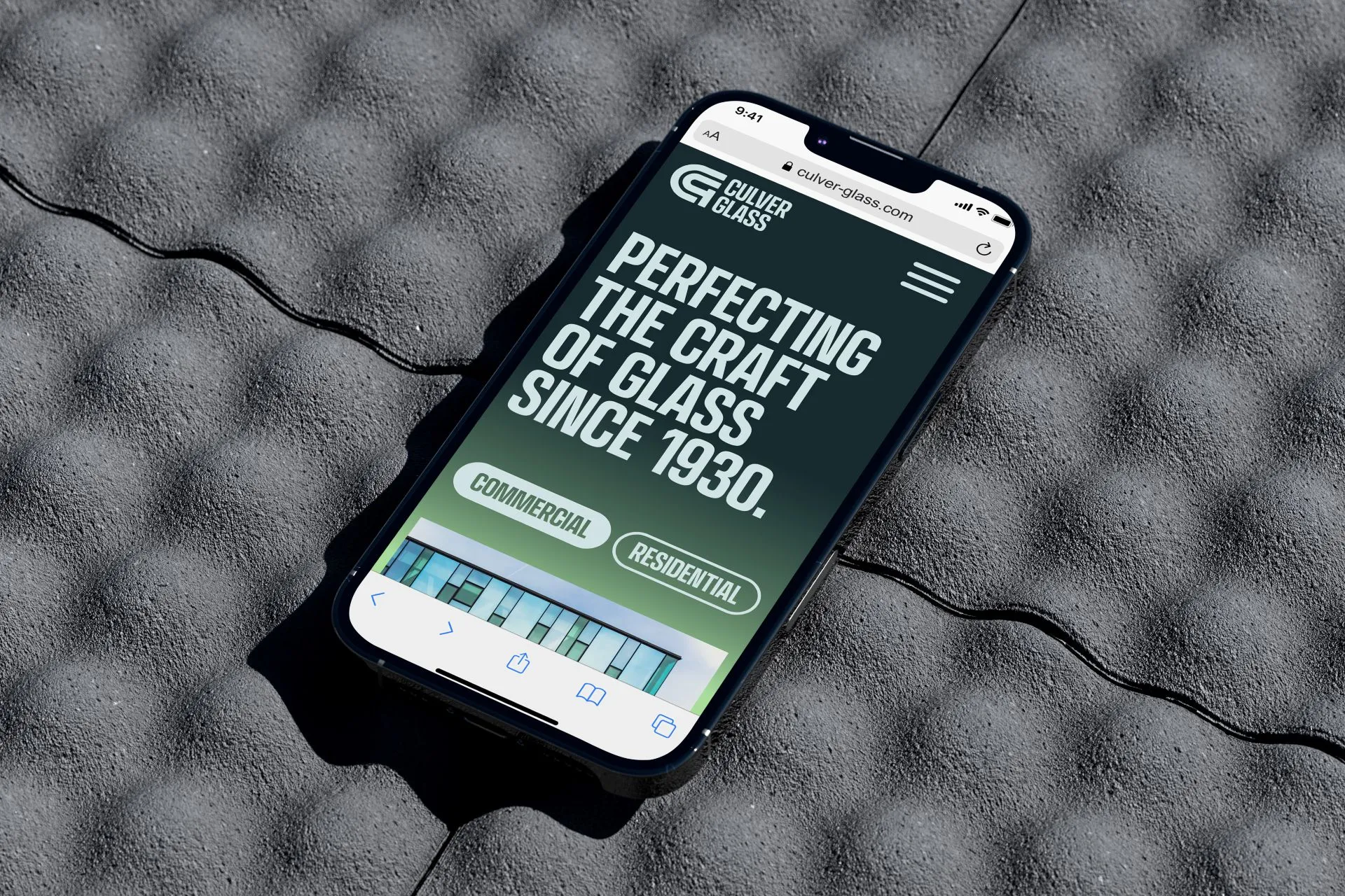 Smartphone displaying Culver Glass website with the text 'Perfecting the craft of glass since 1930' on a textured gray surface.