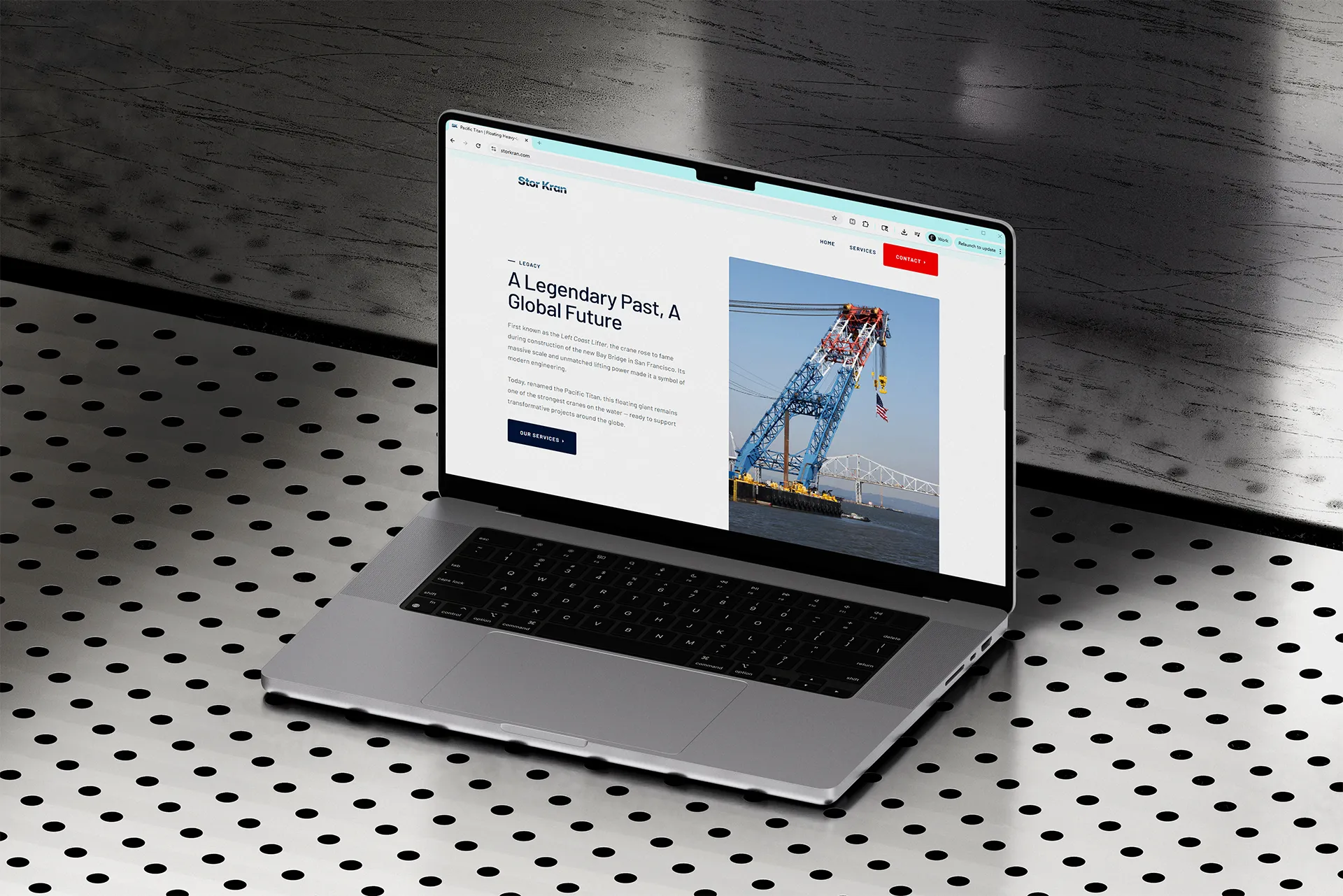 Open laptop displaying a website page titled 'A Legendary Past, A Global Future' with an image of a large blue crane on water near a bridge.