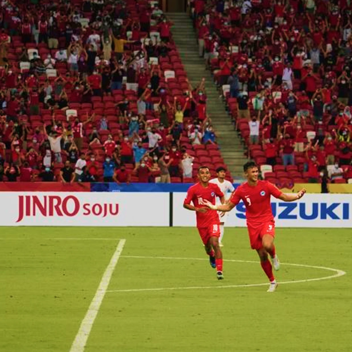 Soccer players celebrating goal on field