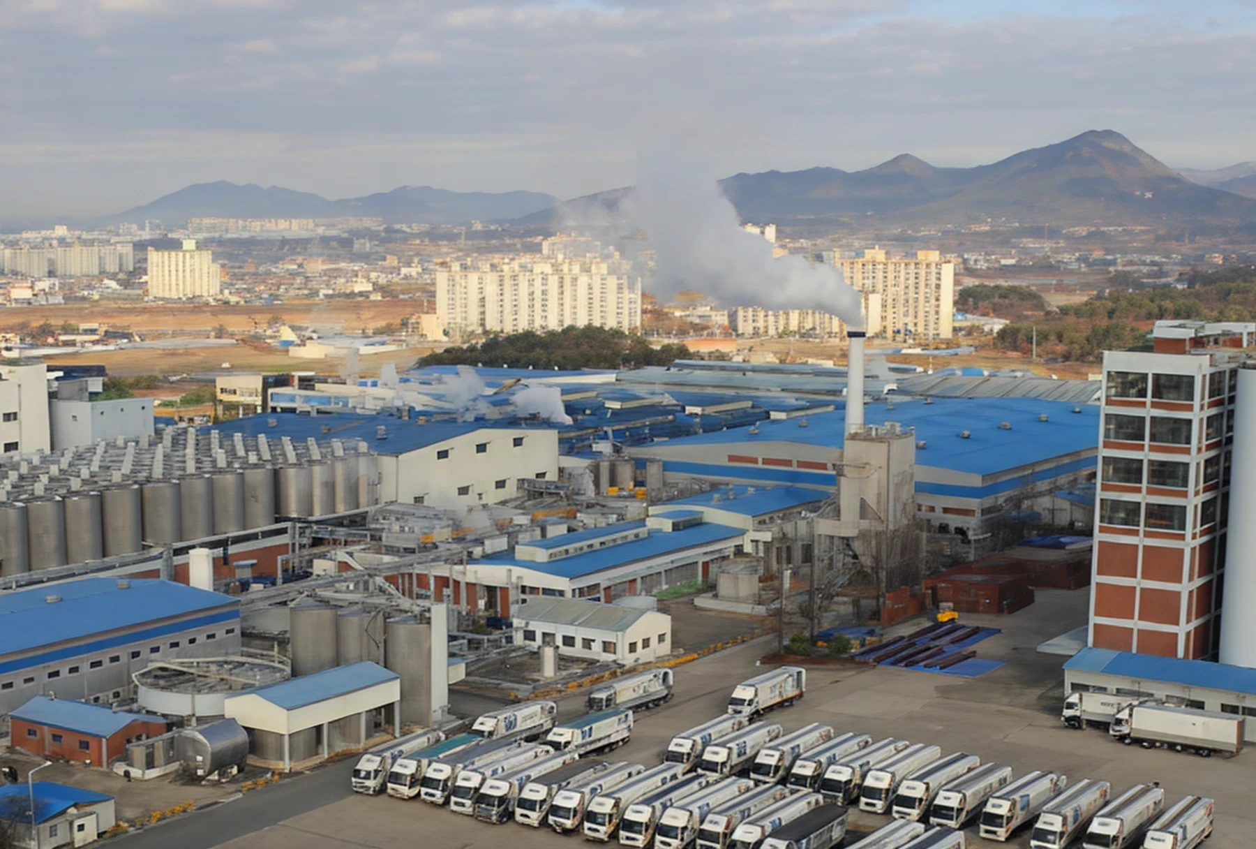 Factory with blue roofs and delivery trucks parked outside