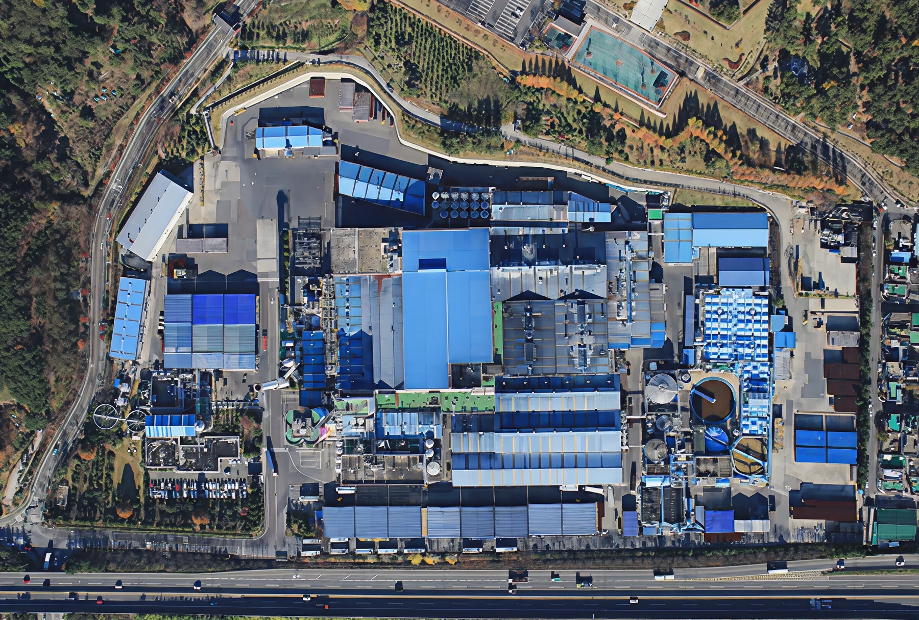 Aerial view of industrial facility with blue roofs