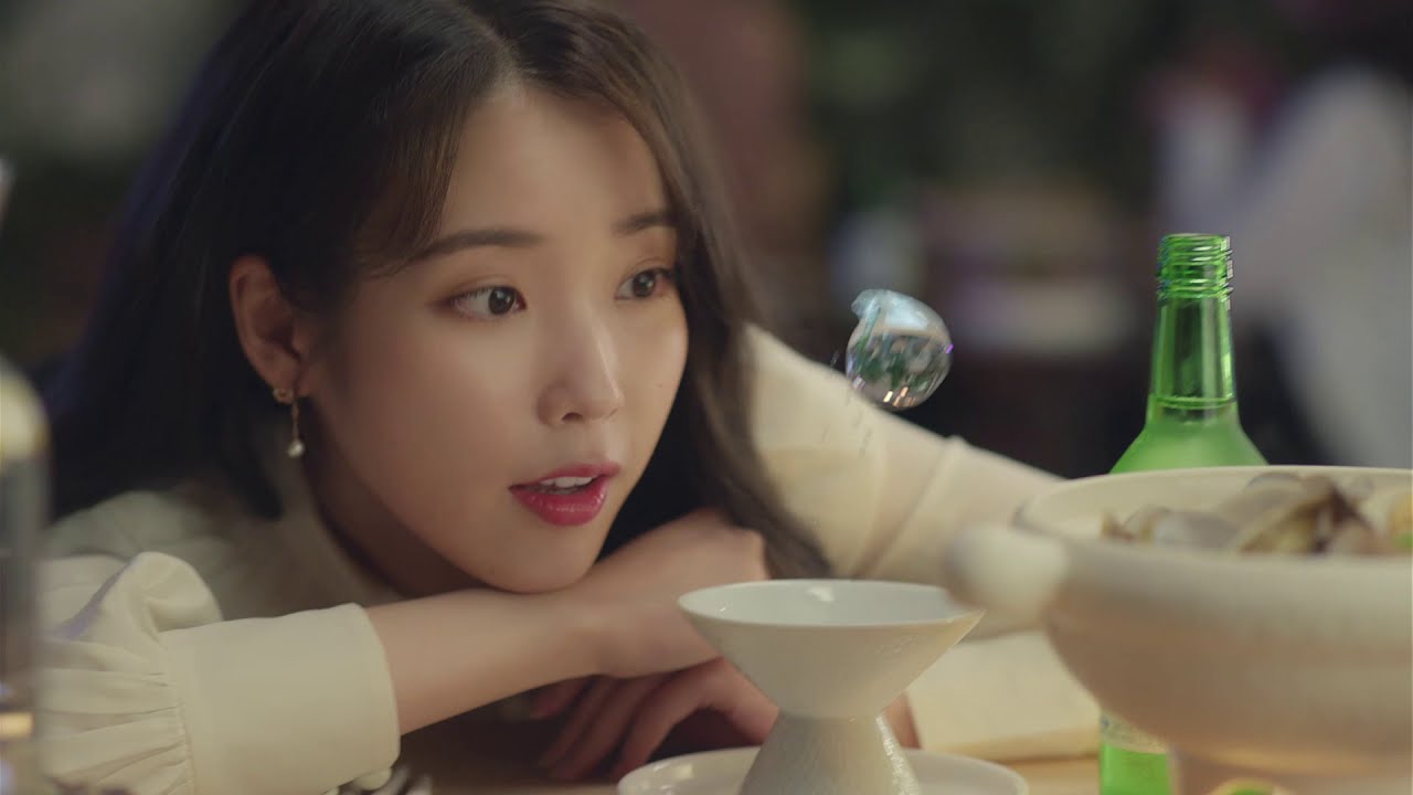Person sitting with soju bottle and bowl
