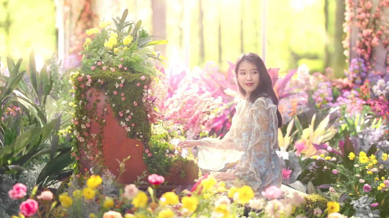Woman sitting in a colorful flower garden