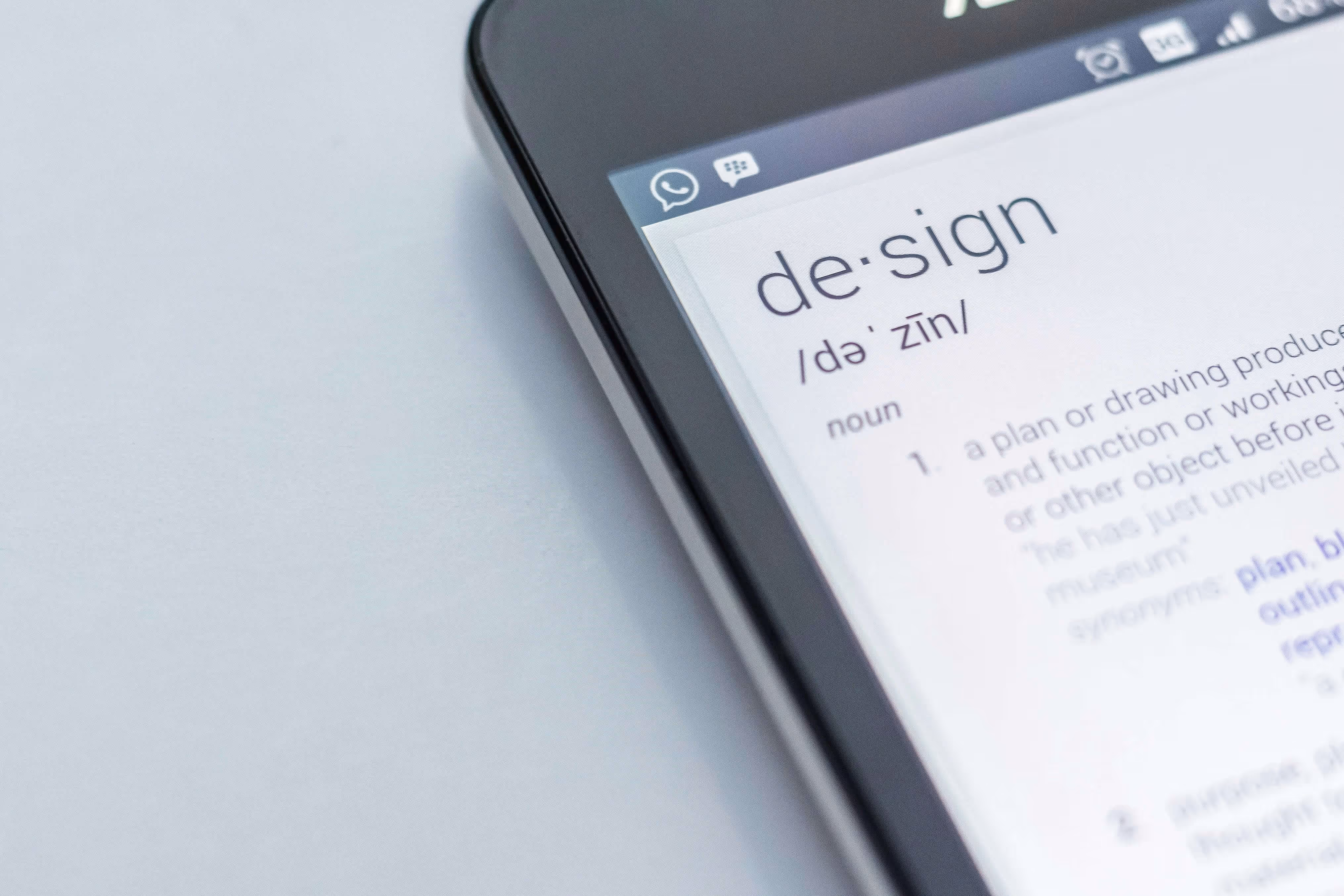 Close-up of a smartphone screen displaying the dictionary definition of the word 'design'.