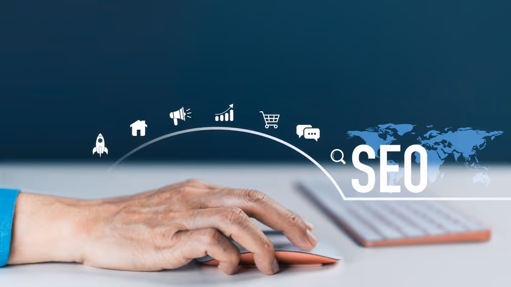 Hand using a computer mouse with digital icons and the text SEO over a blurred keyboard background.