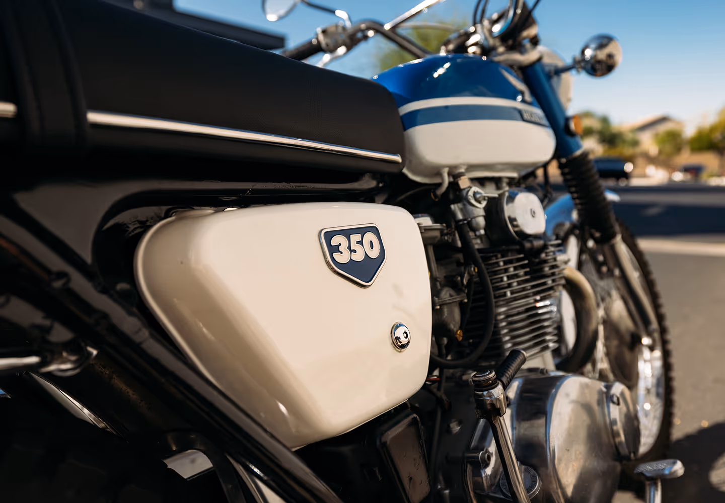 Close-up of a blue and white vintage motorcycle with a '350' badge on the side panel.