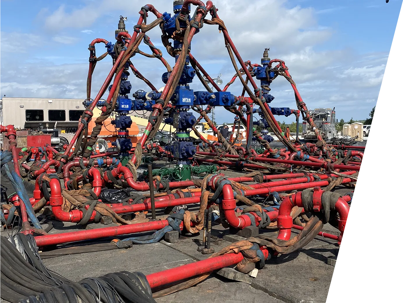 A large group of pipes sitting on top of a cement ground.