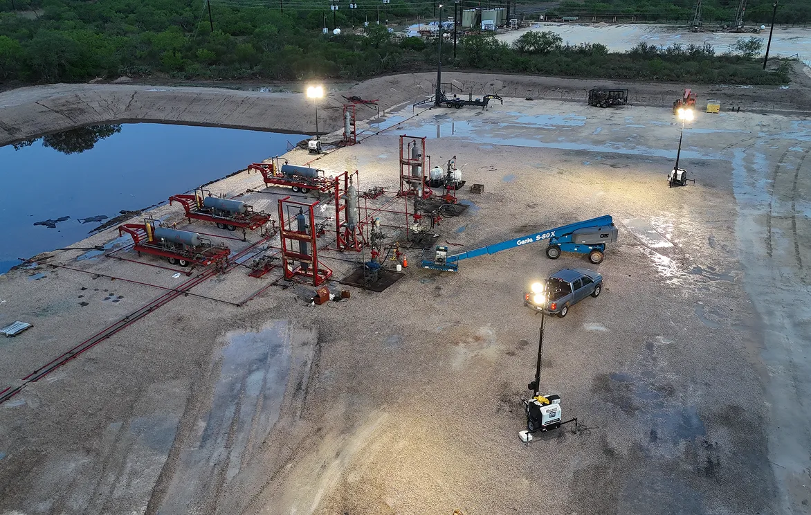A construction site with a lot of equipment and lights.
