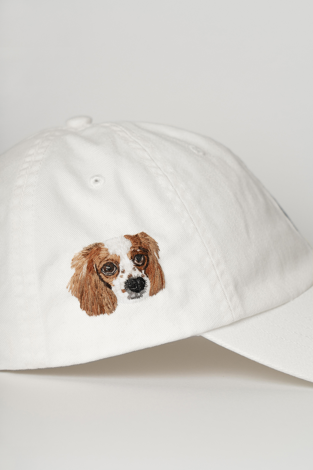Tan baseball cap with an embroidered dog face on the side.