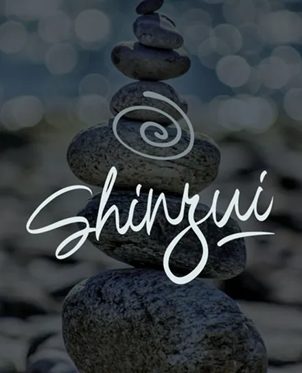 Logo du projet Shinzui, salon de massage indépendant à l’univers zen, superposé sur un empilement de galets symbolisant l’équilibre et la sérénité.