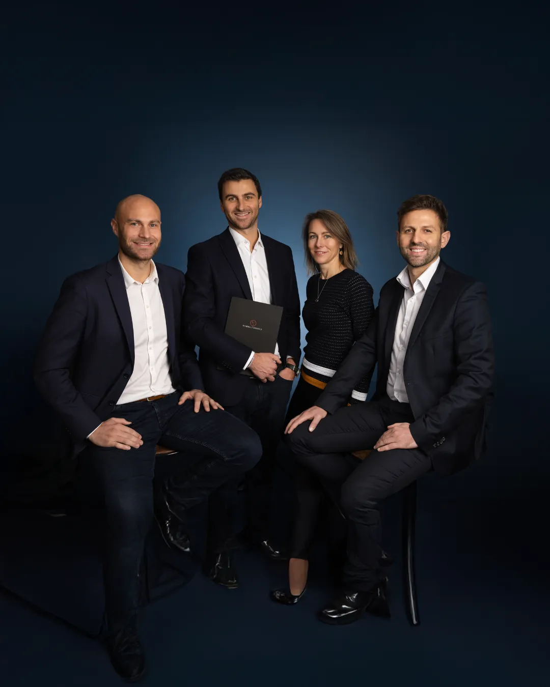 L'équipe de Norma Conseils en costume, photographiée en studio sur fond sombre