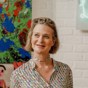 Portret van vrouw met blond haar, kleurrijke blouse en choker, moderne kunst op achtergrond, zakelijke profielfoto