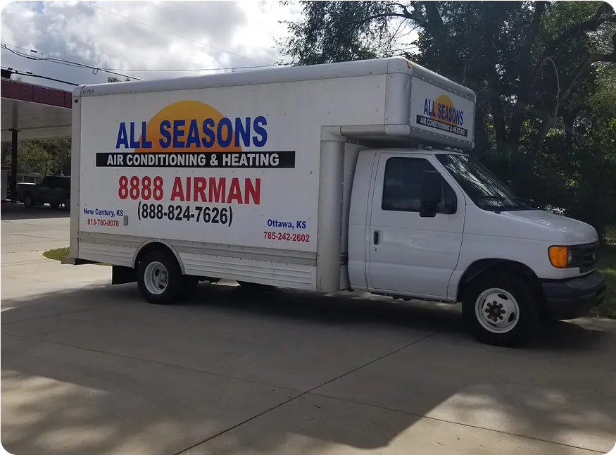 White box truck parked outdoors with All Seasons Air Conditioning & Heating advertisement on its side, including contact numbers and locations in Kansas.