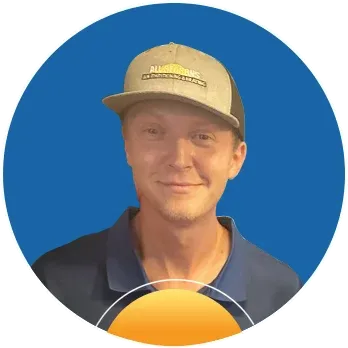 Man wearing a tan cap and blue collared shirt smiling against a blue circular background.