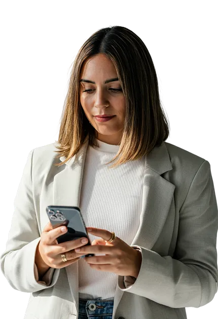 Woman with shoulder-length brown hair wearing a white blazer and sweater looking at her smartphone.