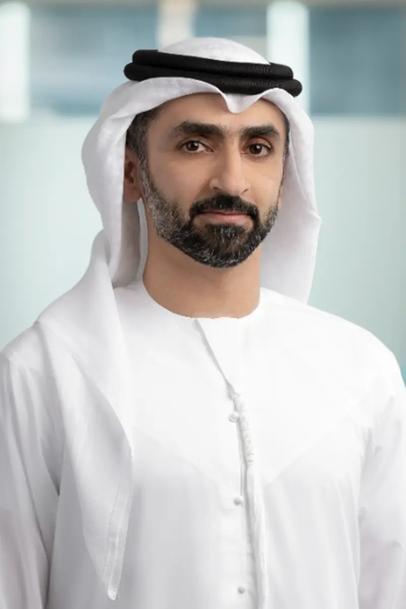 Portrait of a man wearing traditional white Middle Eastern attire and a white headscarf with a black agal.