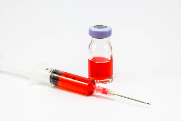 Injectable medication syringe, vial, and travel supplies organized for safe transport during a trip.