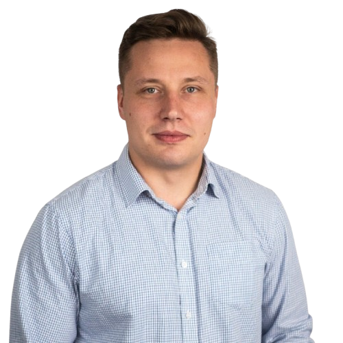 Smiling man wearing a light blue checkered button-up shirt against a transparent background.