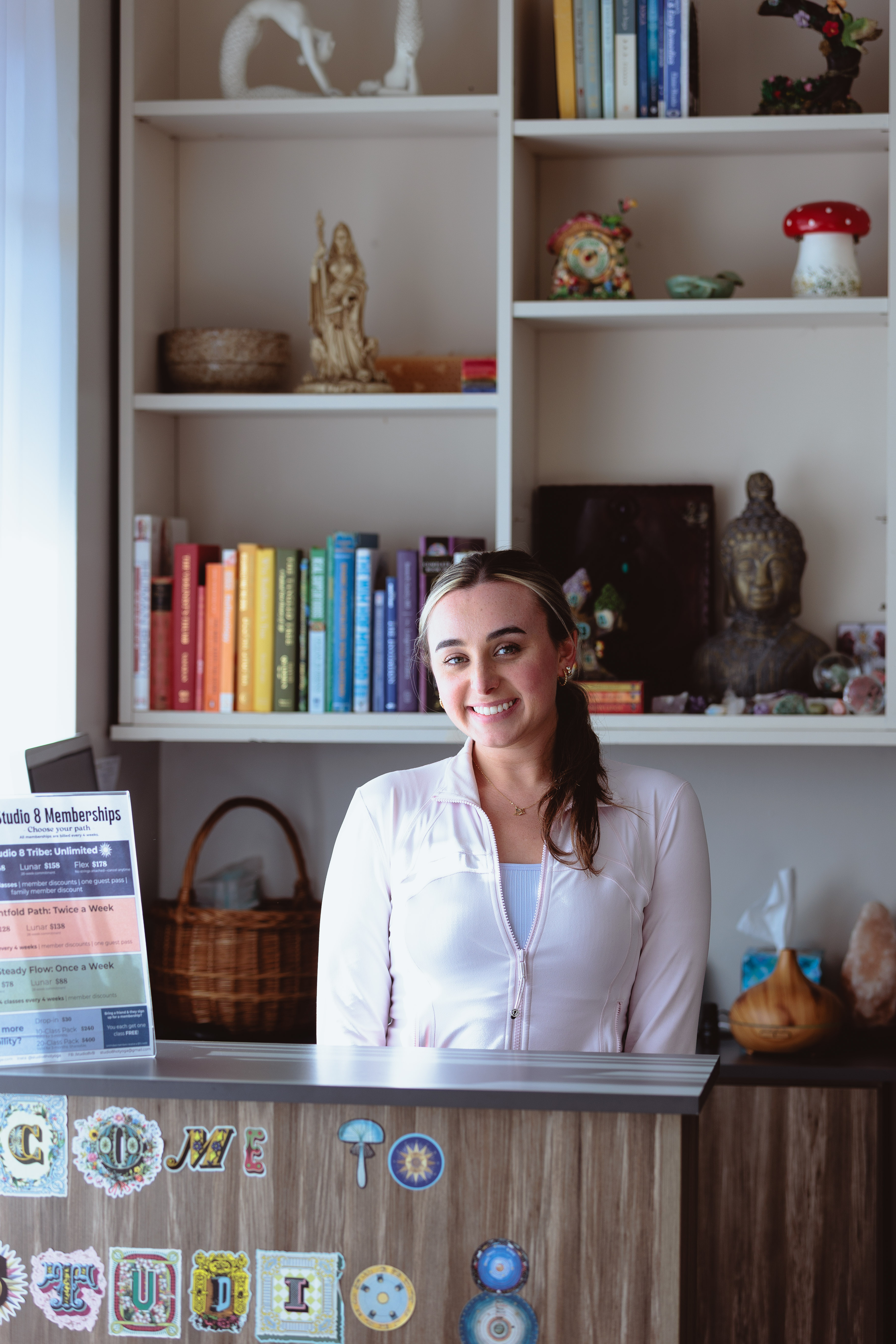 Young woman in beige tank top with eyes closed, practicing yoga with hands in prayer position outdoors.