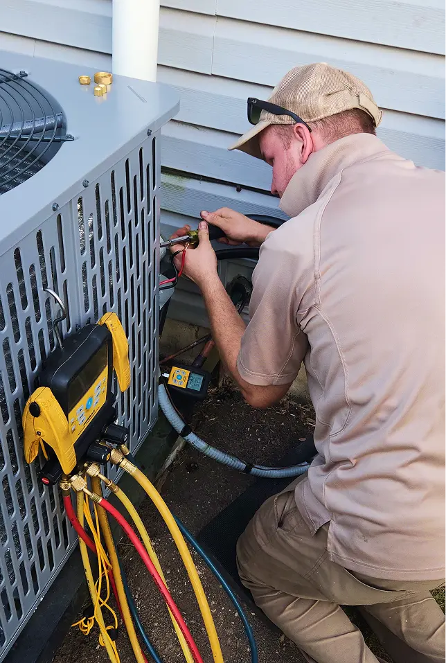 Technician repairing outdoor residential AC unit.