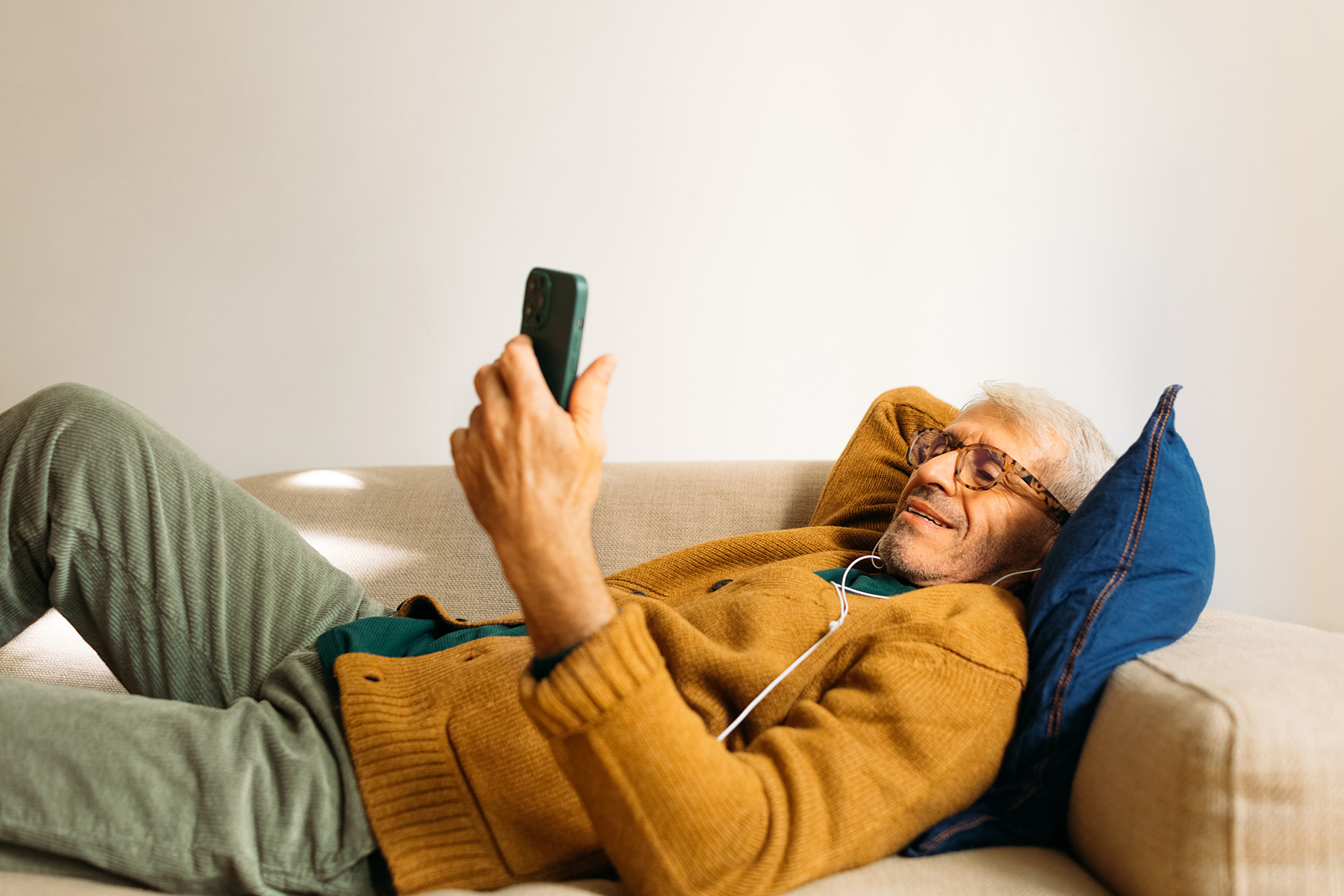 A man lying down looking at his phone