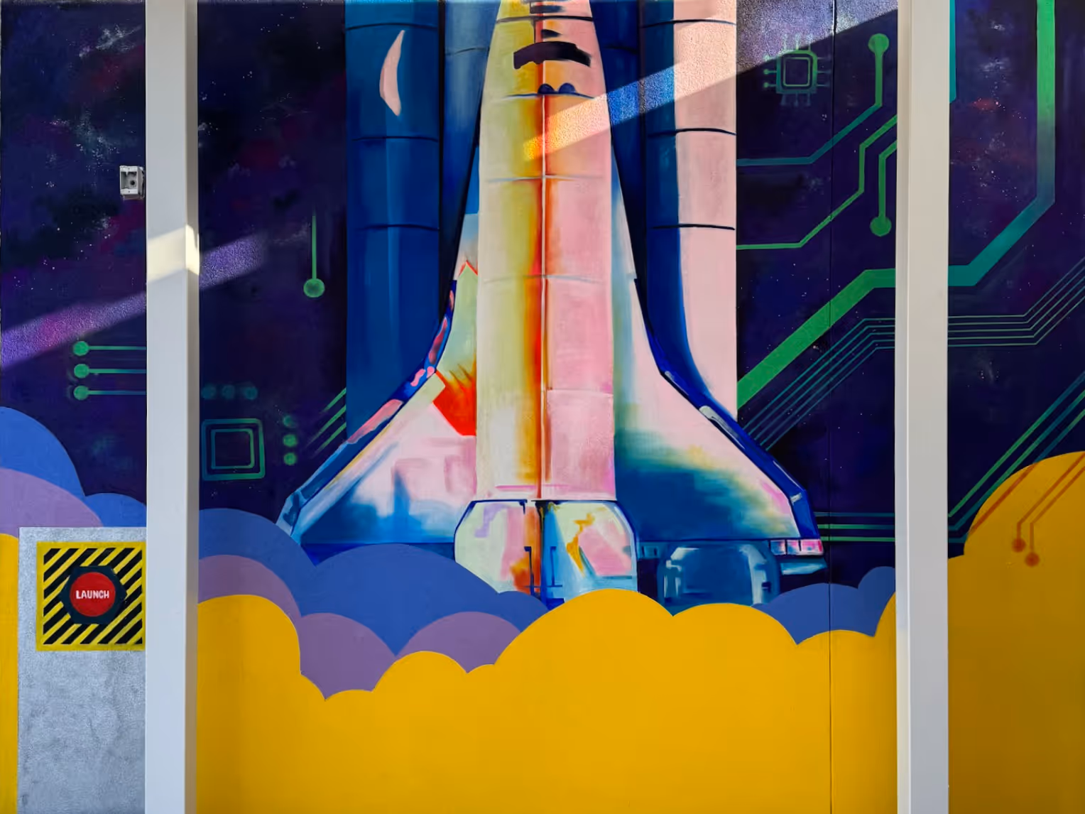 Colorful mural of a space shuttle launching with clouds of smoke and circuit board patterns in the background.