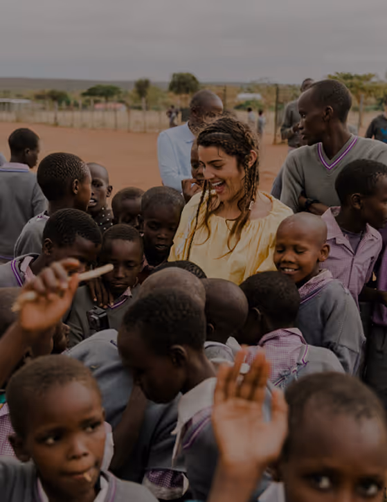 A joyful scene of guests engaging with local Maasai schoolchildren, showcasing Cottar’s focus on community empowerment and cultural exchange.