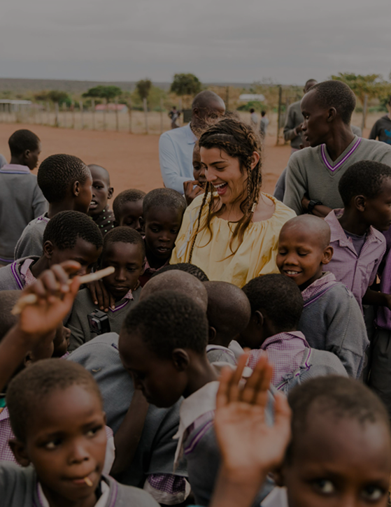A joyful scene of guests engaging with local Maasai schoolchildren, showcasing Cottar’s focus on community empowerment and cultural exchange.