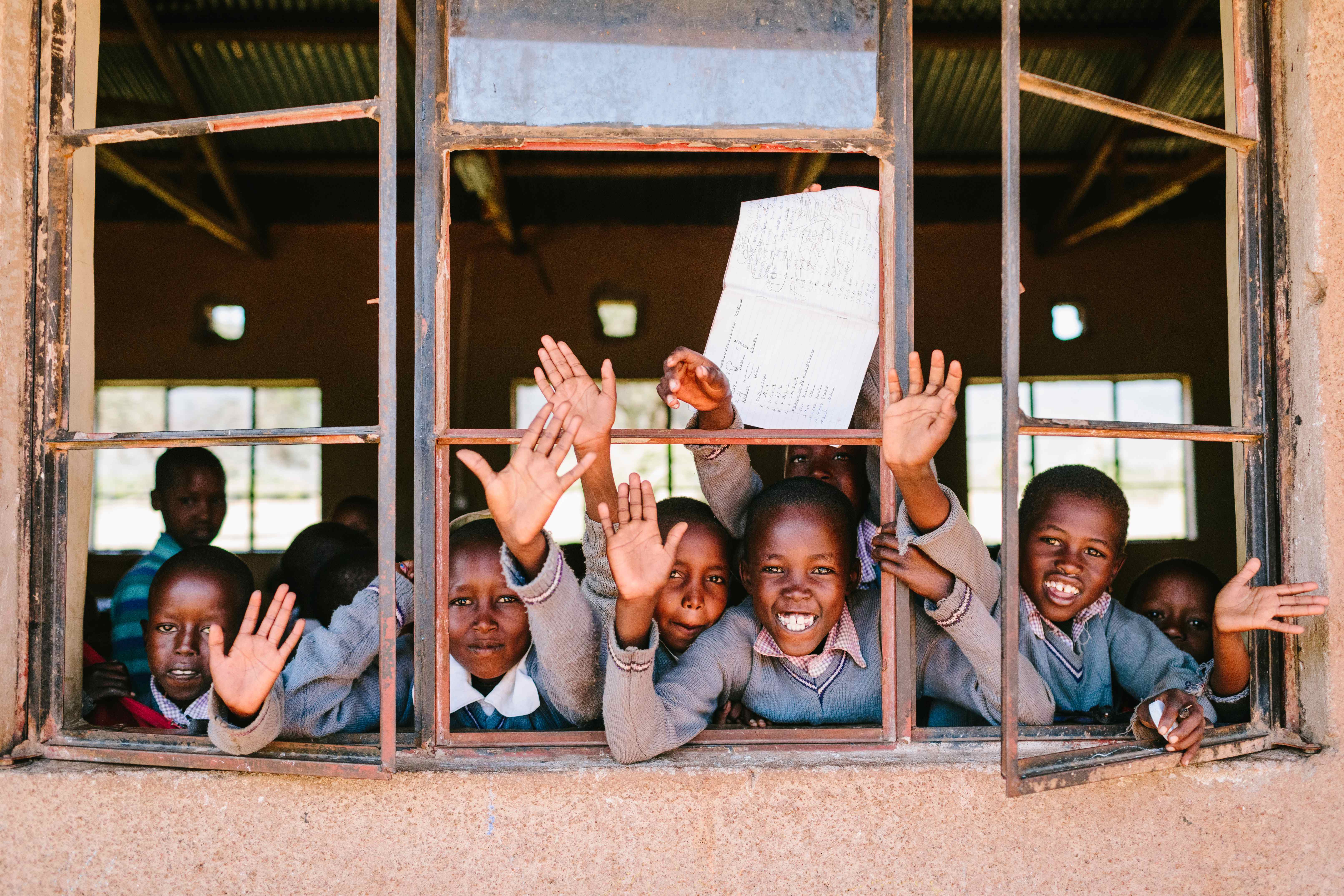 Cottar’s team and local Maasai students outside a rural school, representing education initiatives with The Maa Trust.