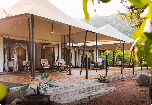 Exterior view of Cottar’s 1920s Camp with luxury canvas tents and open verandas in Kenya’s Maasai Mara.