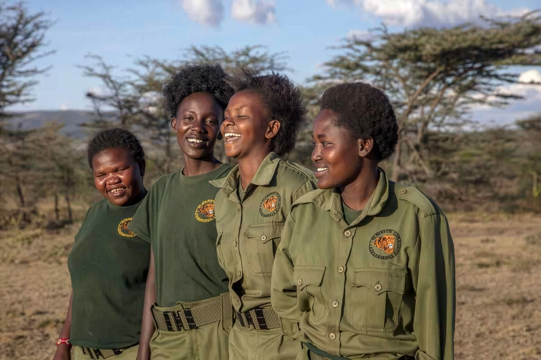 A female Maasai ranger standing on the plains of the Olderkesi Conservancy, representing women in conservation.