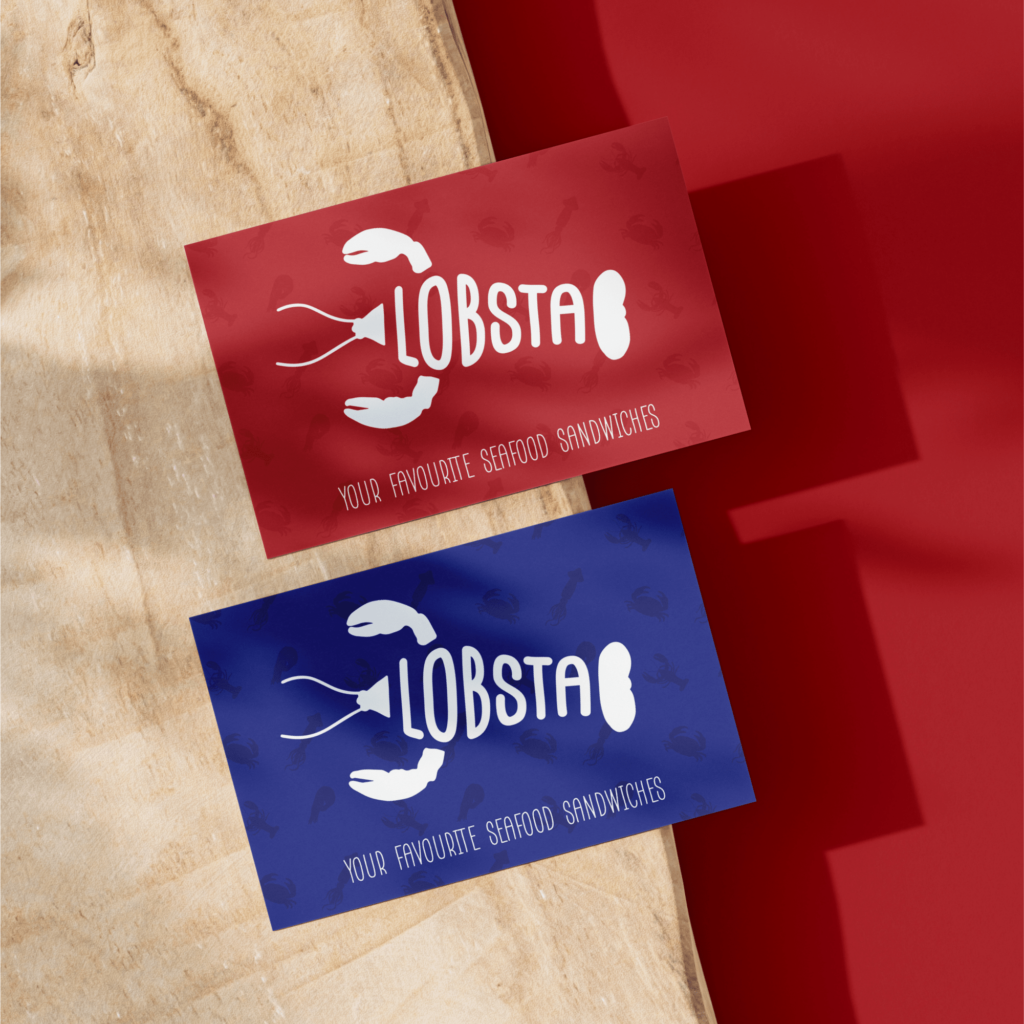 Business cards for Lobsta seafood restaurant in France featuring playful lobster claw logo and tagline 'Your Favourite Seafood Sandwiches' on red and blue backgrounds