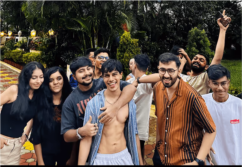 Cheerful group of young friends posing together in lush garden setting