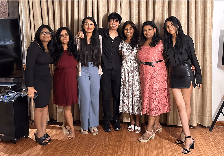 Group of seven people posing together in stylish attire