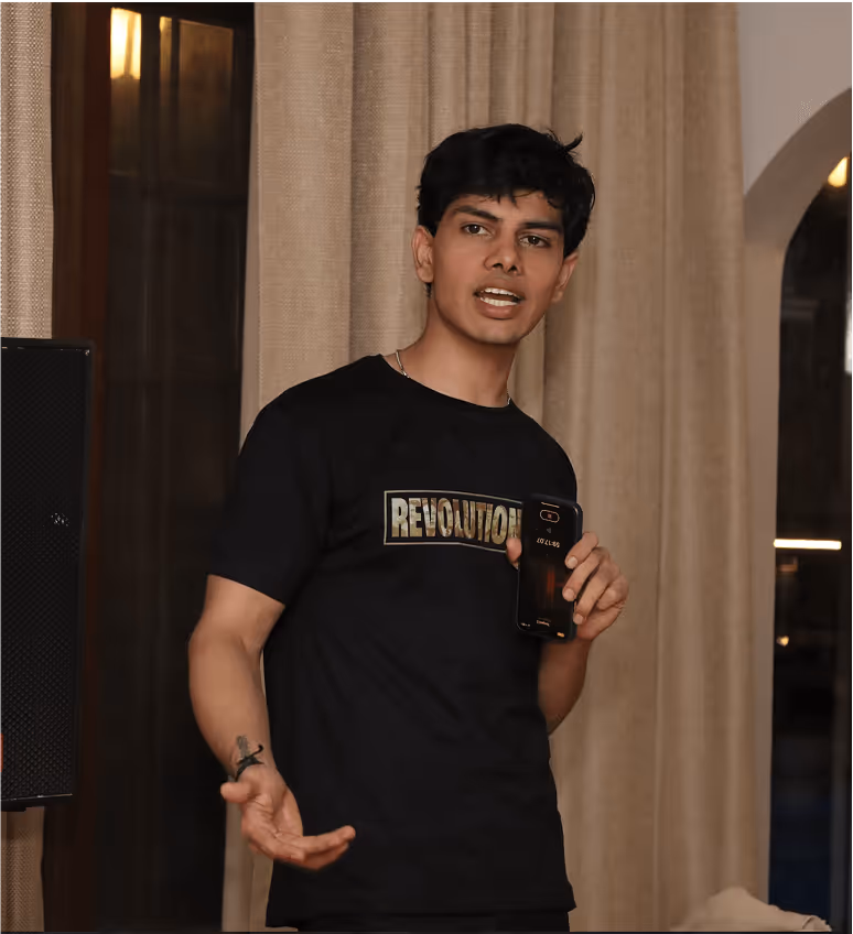 Person in black Revolution t-shirt gesturing while speaking indoors