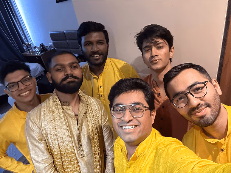 Six friends in yellow shirts posing together for a group selfie