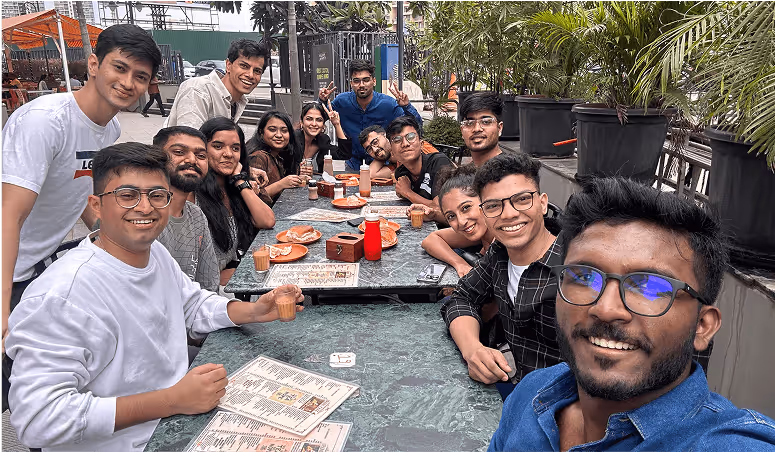 Group of friends enjoying a meal together at an outdoor table