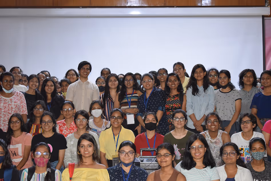 Large group of students posing together in a classroom or meeting room