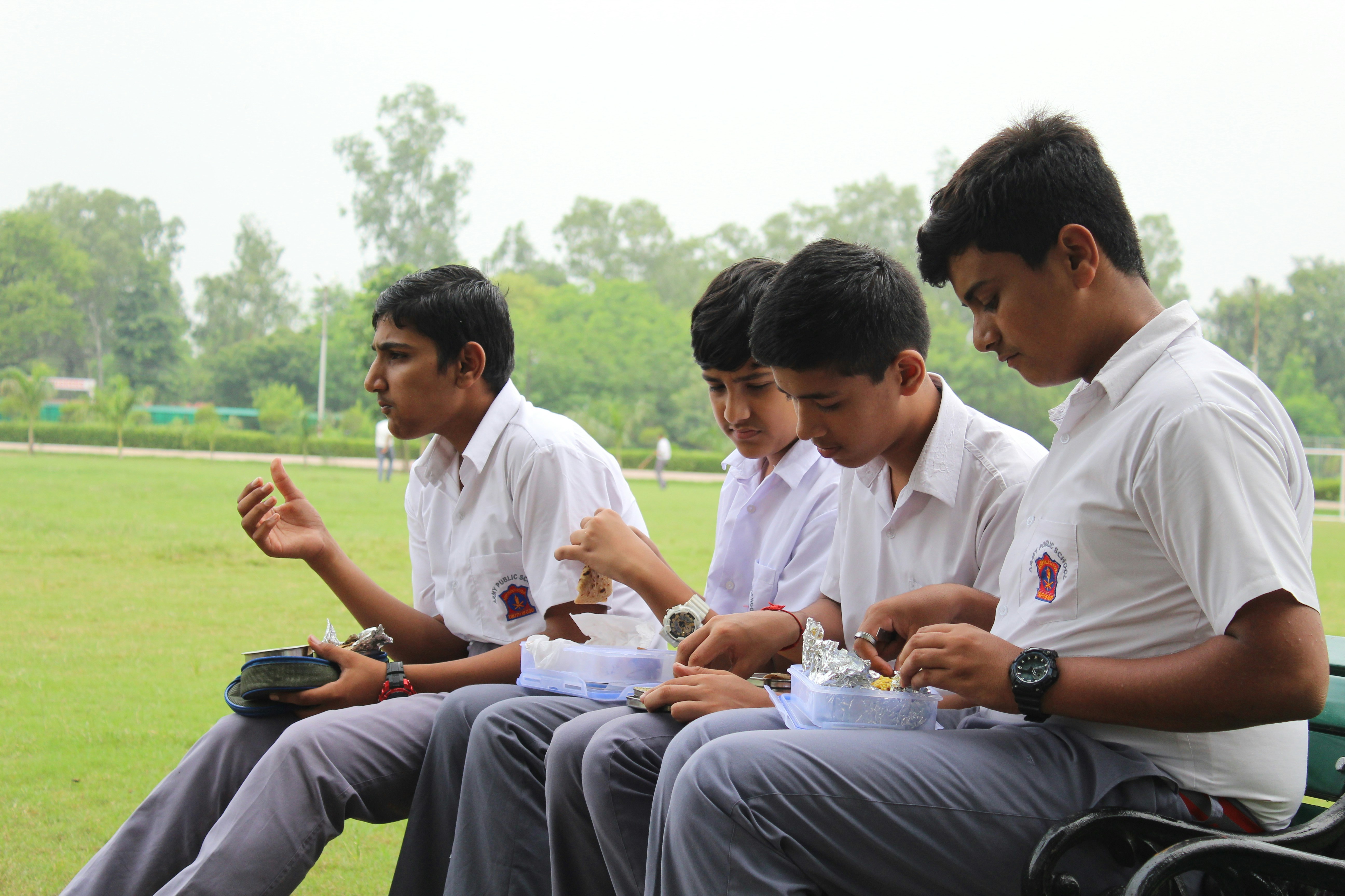 Indian primary school children eating lunch together during a school break