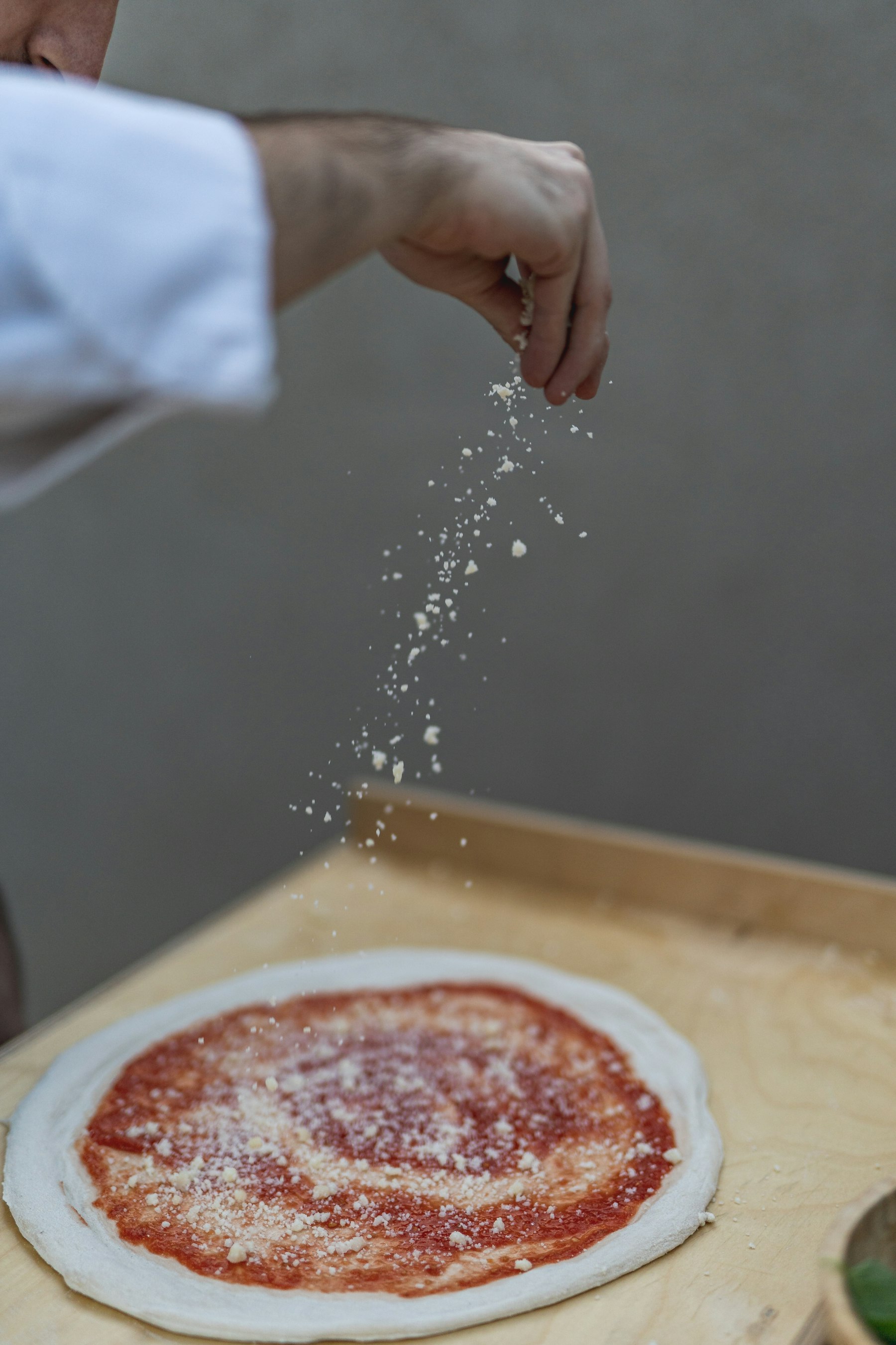 A hand seasoning food with salt, highlighting the role of iodized salt in a vegan diet
