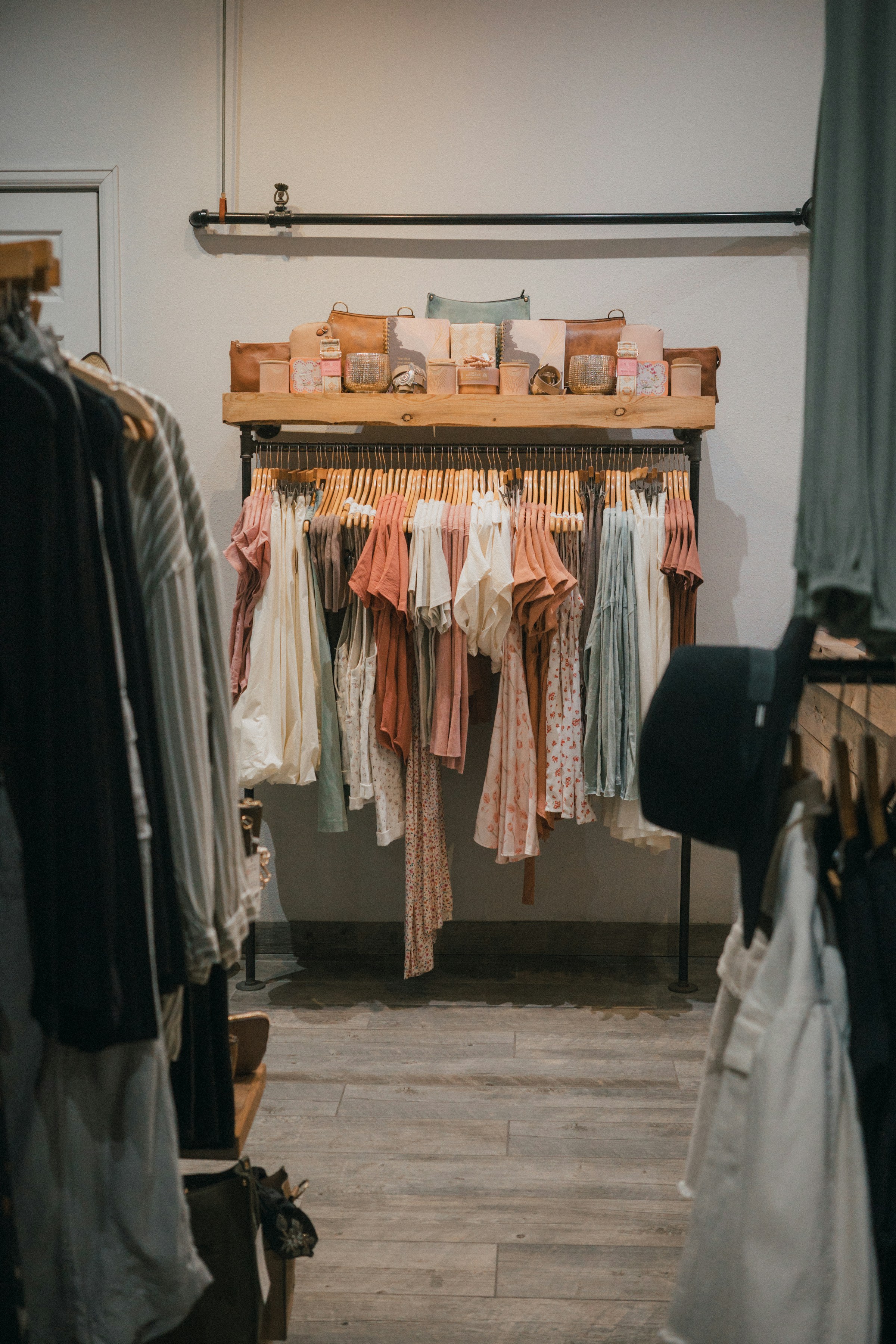 Colourful garments hanging on racks inside a clothing boutique
