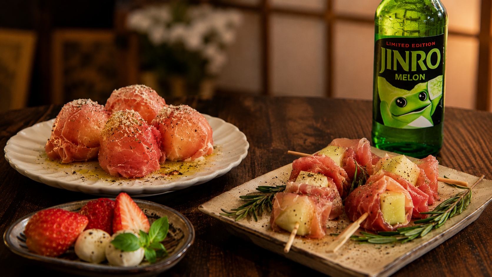 Jamón served with melon and small home anju plates alongside JINRO Melon soju