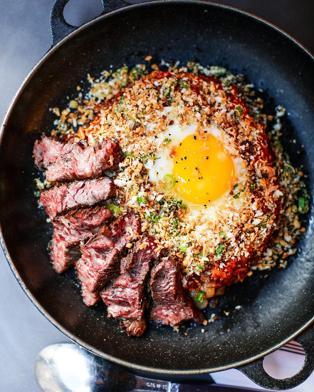 Osamil NYC kimchi fried rice topped with prime hanger steak and a runny fried egg