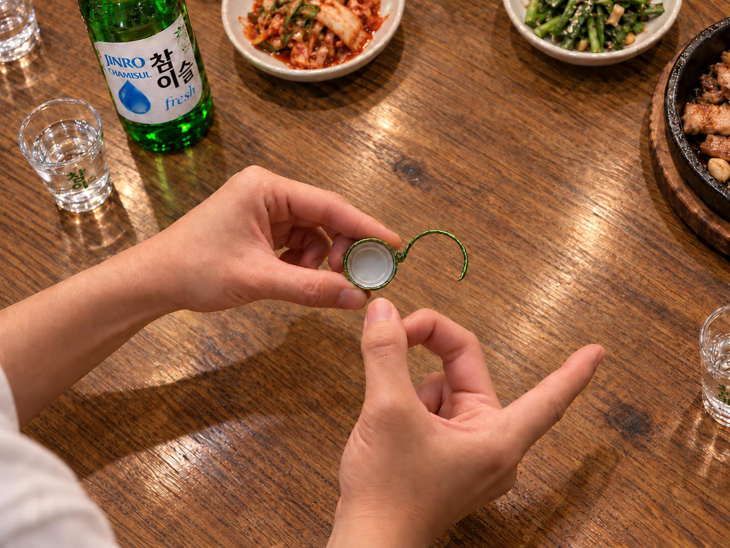 Hands holding a bottle cap for a flicking game