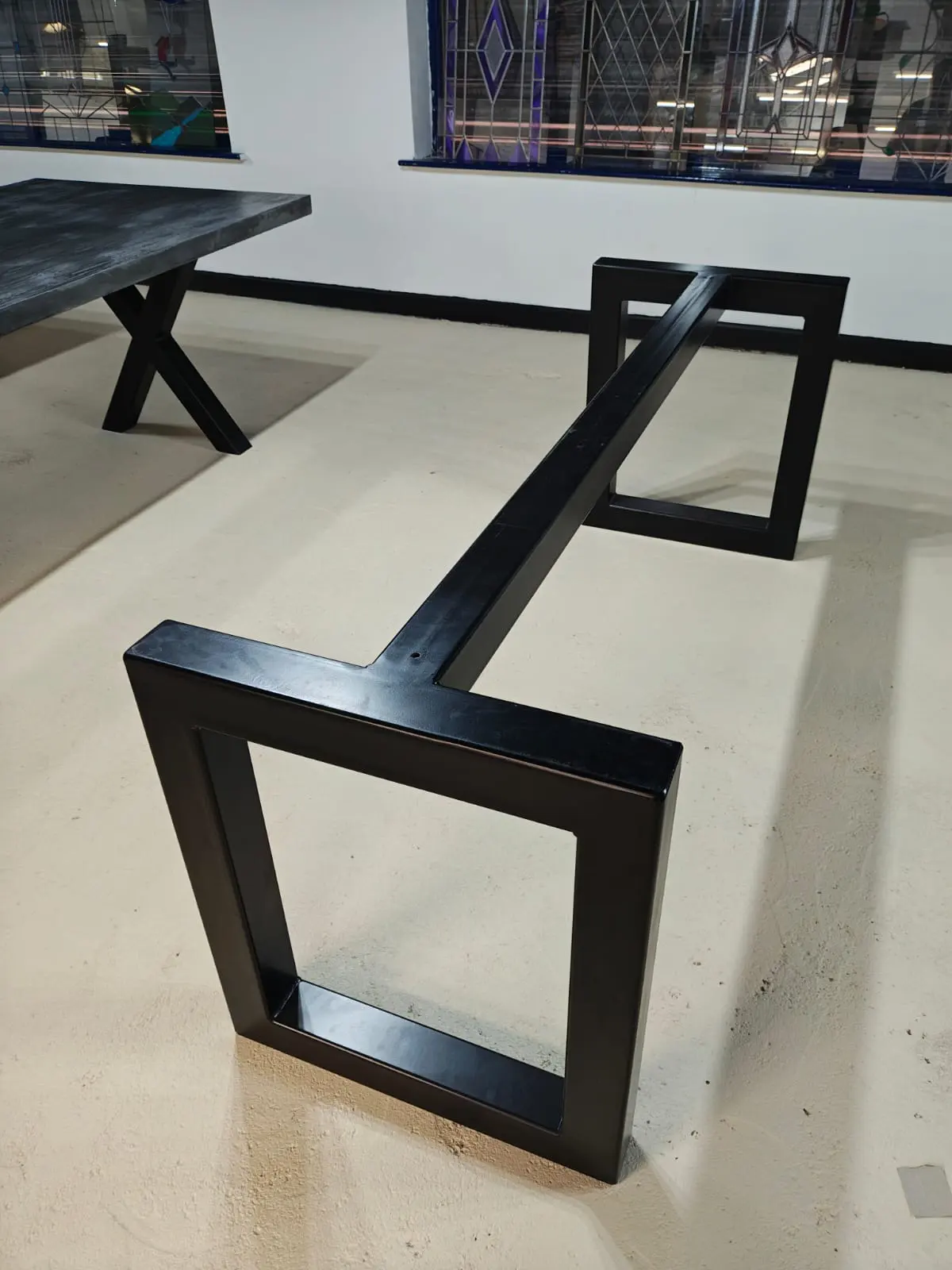 Box frame steel table base with clean architectural lines
