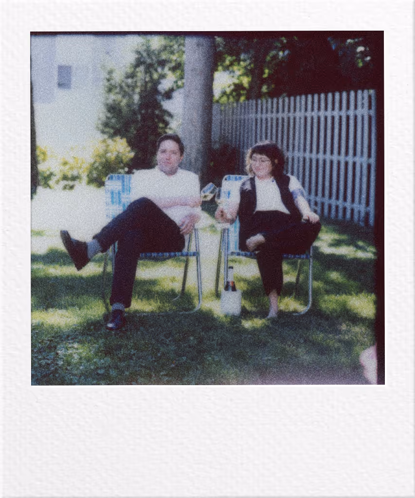Two people sitting on chairs in backyard, relaxed and casual