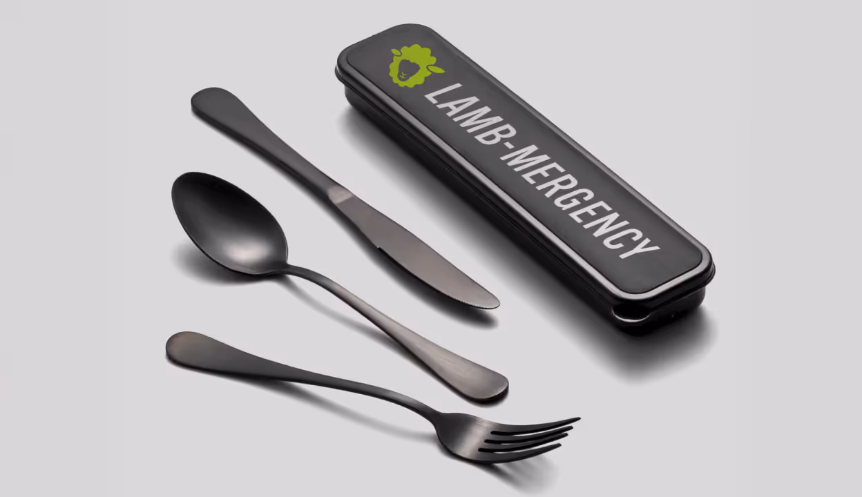 Black utensils and Lamb Mergency travel case on white background