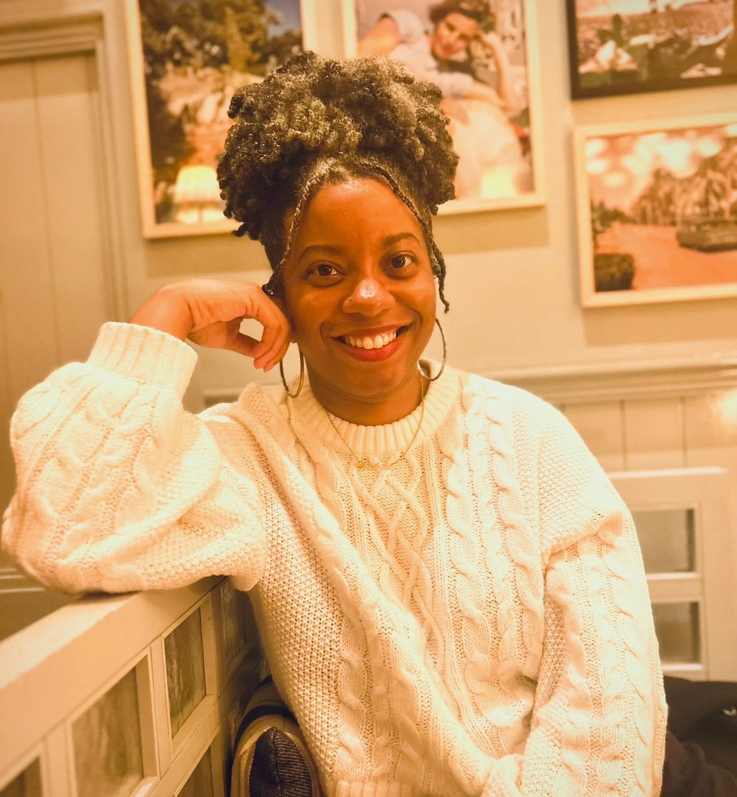woman smiling at dinner in a white sweater